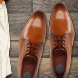 Men's Bugatti derby cognac leather shoes with a pointed toe and plain toe featuring a stacked heel , a leather outsole , and laces fastening.