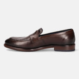 A brown Men's bugatti Venetian Loafers featuring a round toe apron toe, stacked heel. Made from premium genuine leather with a durable leather outsole, this slip-on design offers both style and comfort.