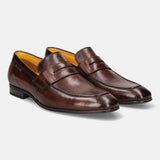 A brown Men's bugatti Penny Loafer featuring a round apron toe, moulded heel. Made from premium genuine leather with a durable high quality synthetic outsole, this slip-on design offers both style and comfort.