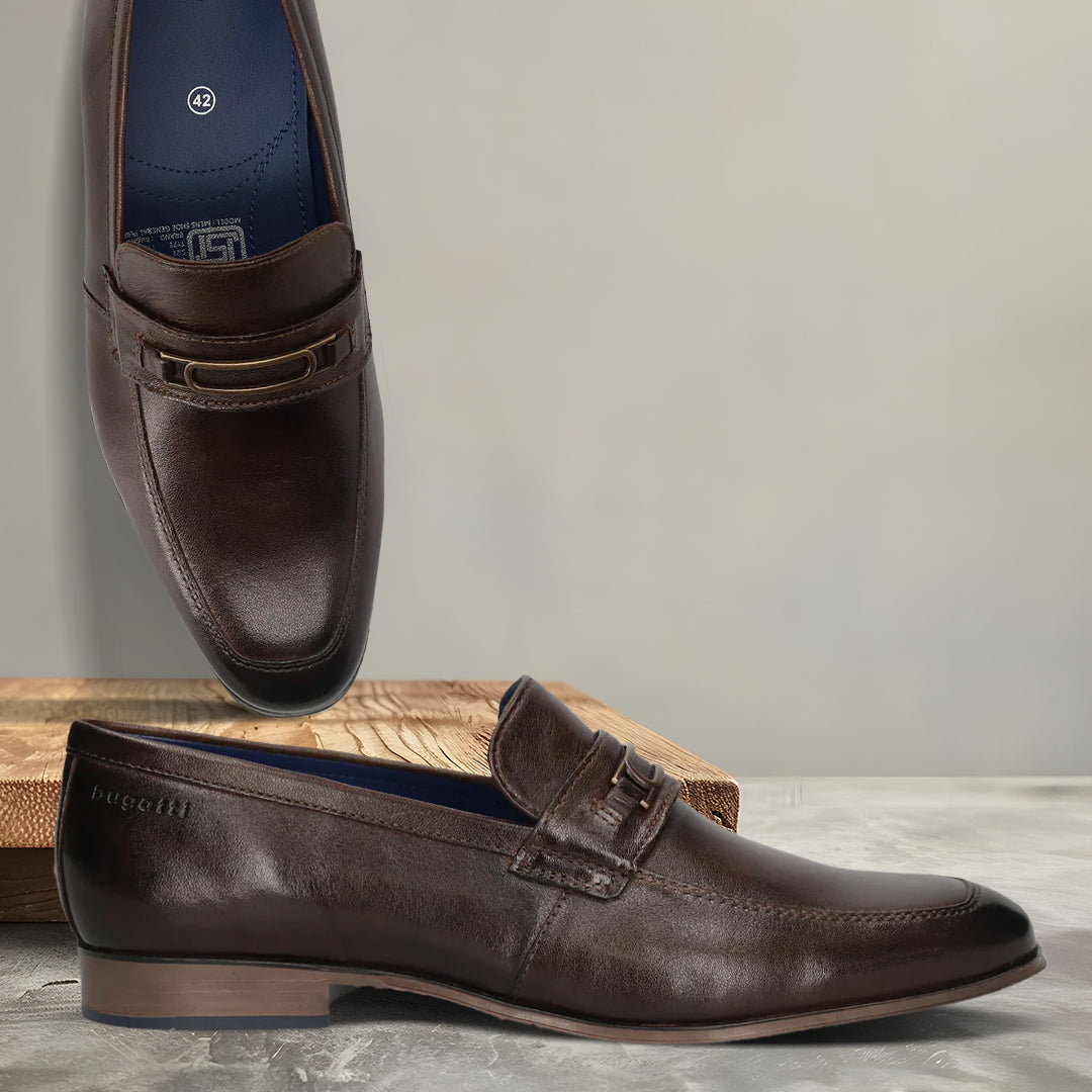 A brown Men's bugatti Bit Loafer featuring a round toe apron toe, moulded  heel. Made from premium genuine leather with a durable high quality synthetic outsole, this slip-on design offers both style and comfort.