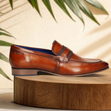 Men's Bugatti penny loafer cognac leather shoes with a round toe and apron toe featuring a moulded heel , a pvc outsole.