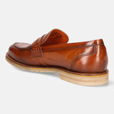 A cognac Men's bugatti Penny Loafer featuring a round apron toe, stacked heel, and a extra wide fit. Made from premium genuine leather with a durable eva outsole, this slip-on design offers both style and comfort.