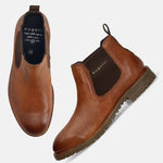 A cognac Men's bugatti Chelsea Boots featuring a round toe plain toe, moulded  heel, and a wide fit. Made from premium genuine leather with a durable tr outsole, this elastic design offers both style and comfort.