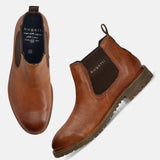 A cognac Men's bugatti Chelsea Boots featuring a round toe plain toe, moulded  heel, and a wide fit. Made from premium genuine leather with a durable tr outsole, this elastic design offers both style and comfort.