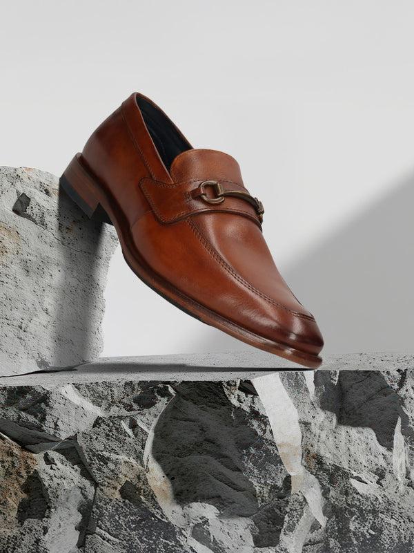 A cognac Men's bugatti Bit Loafer featuring a round toe apron toe, stacked heel. Made from premium genuine leather with a durable leather outsole, this slip-on design offers both style and comfort.