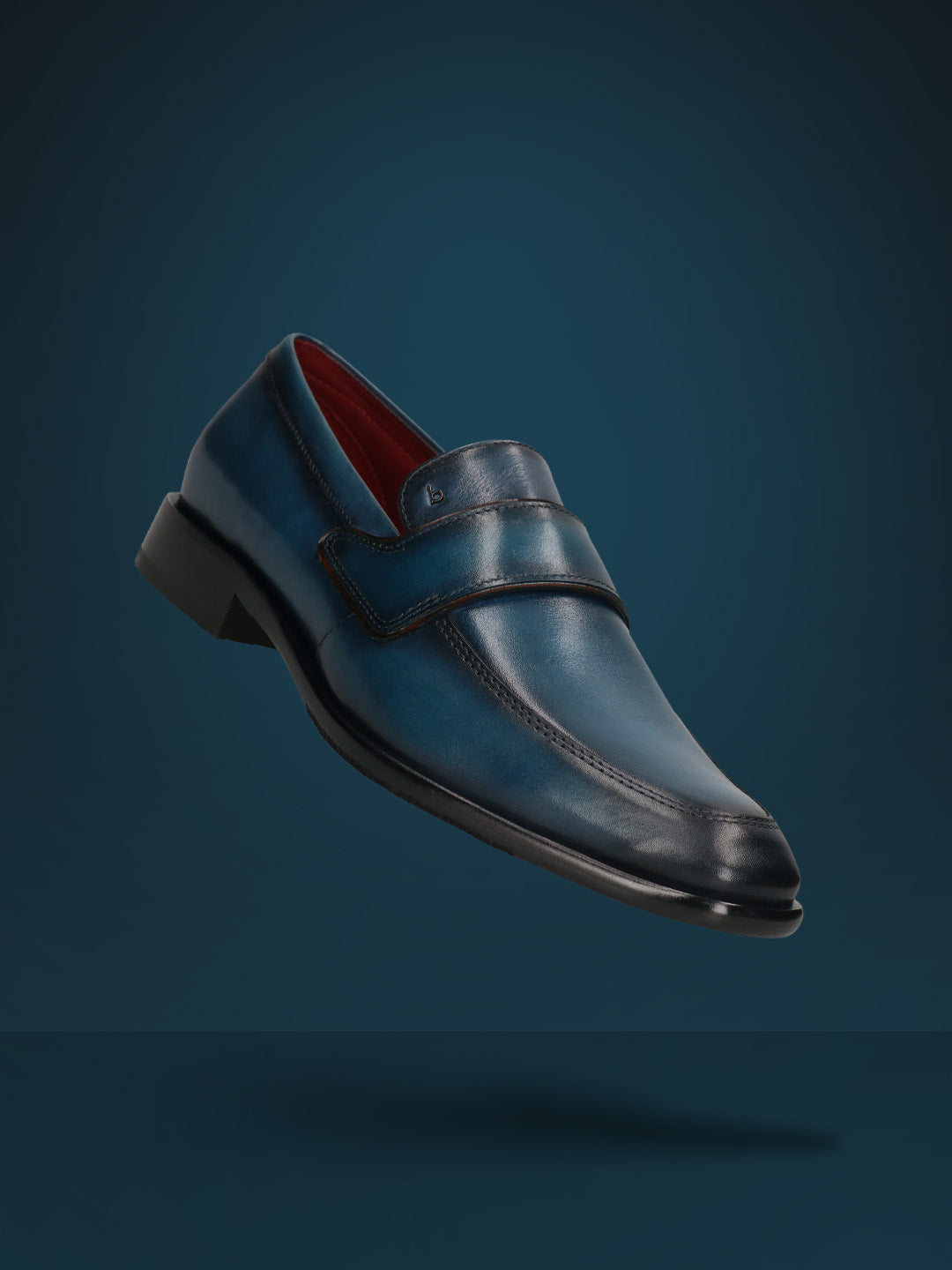 A blue Men's bugatti Penny Loafer featuring a round toe apron toe, stacked heel. Made from premium genuine leather with a durable leather outsole, this slip-on design offers both style and comfort.
