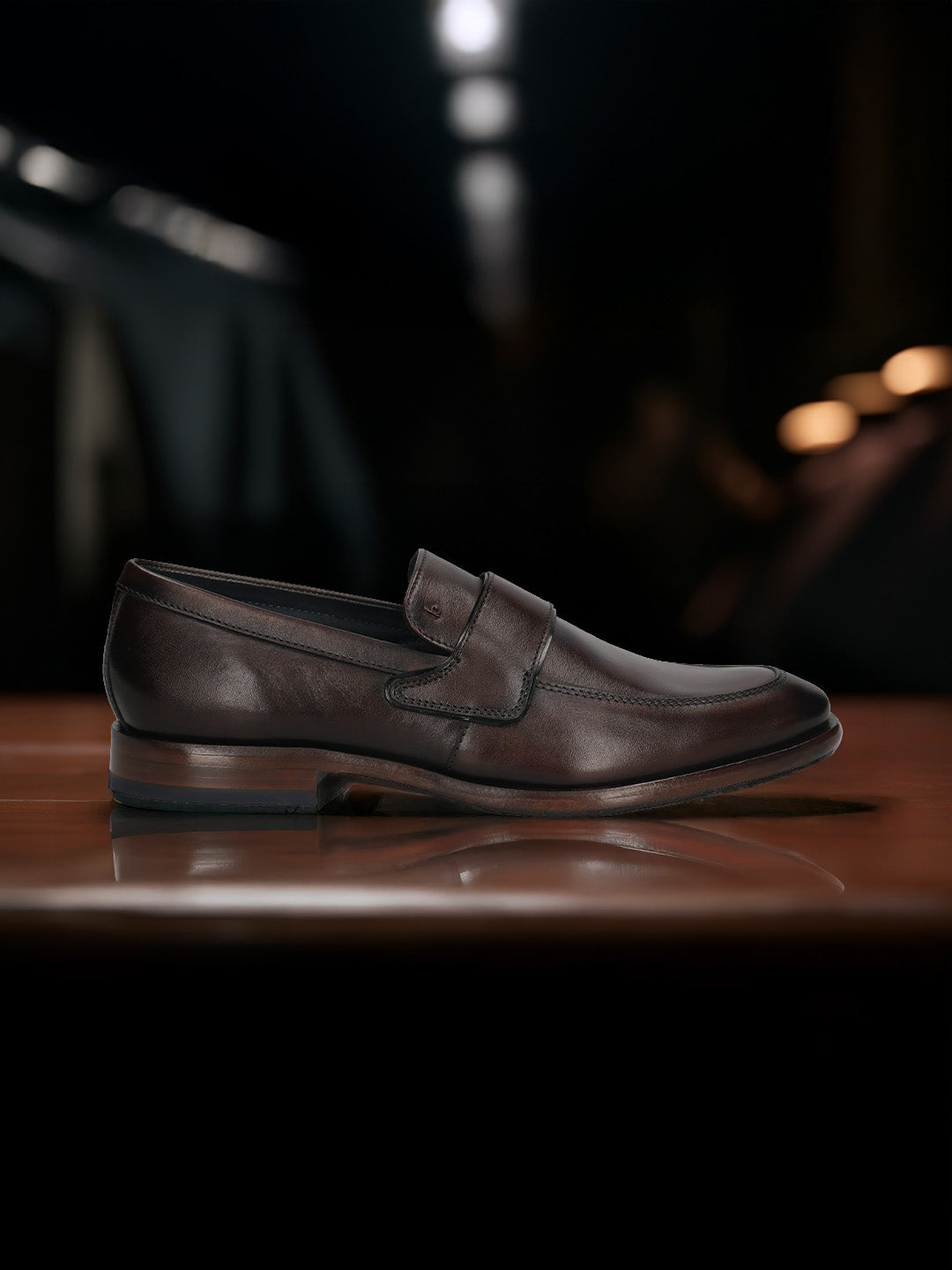 A brown Men's bugatti Penny Loafer featuring a round toe apron toe, stacked heel. Made from premium genuine leather with a durable leather outsole, this slip-on design offers both style and comfort.