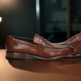 A cognac Men's bugatti Penny Loafer featuring a round toe apron toe, stacked heel. Made from premium genuine leather with a durable leather outsole, this slip-on design offers both style and comfort.