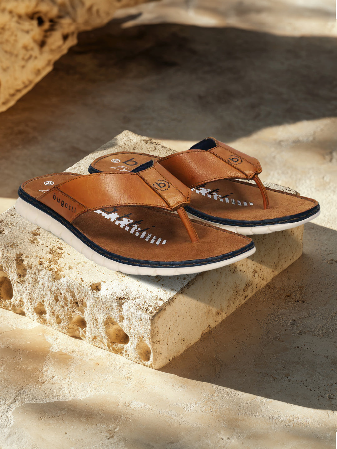 A cognac Men's bugatti Thongs featuring a round open toe, zero heels heel. Made from premium genuine leather with a durable synthetic outsole, this slip-on design offers both style and comfort.