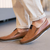 A cognac Men's bugatti Casual Loafers featuring a round plain toe, zero heels heel. Made from premium genuine leather with a durable tr outsole, this slip-on design offers both style and comfort.
