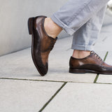 A brown Men's bugatti Brogue featuring a round wingcap, stacked heel. Made from premium genuine leather with a durable leather outsole, this laces design offers both style and comfort.