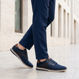 Lifestyle image of bugatti Sandman Comfort Casual Shoes in dark blue, paired with tailored blue trousers.