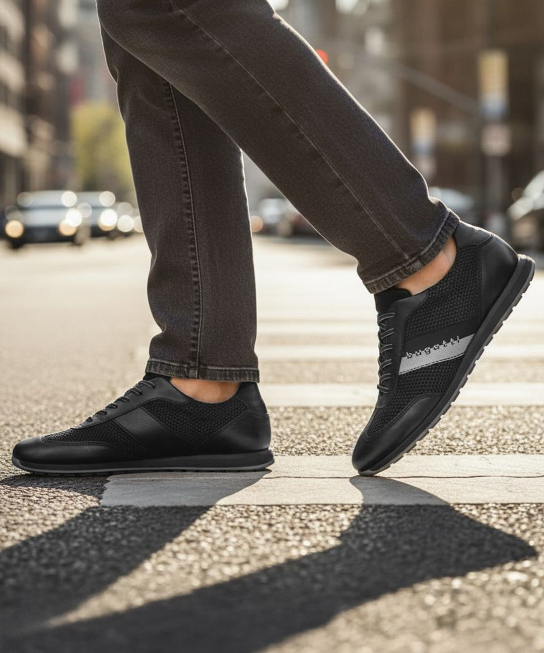 Lifestyle view of black bugatti Thorello sneakers with leather accents and a gray stripe on the side.
