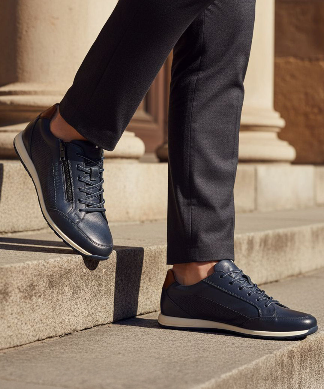 Lifestyle view of bugatti Thorello dark blue premium leather sneakers with side zip, paired with dark dress pants.
