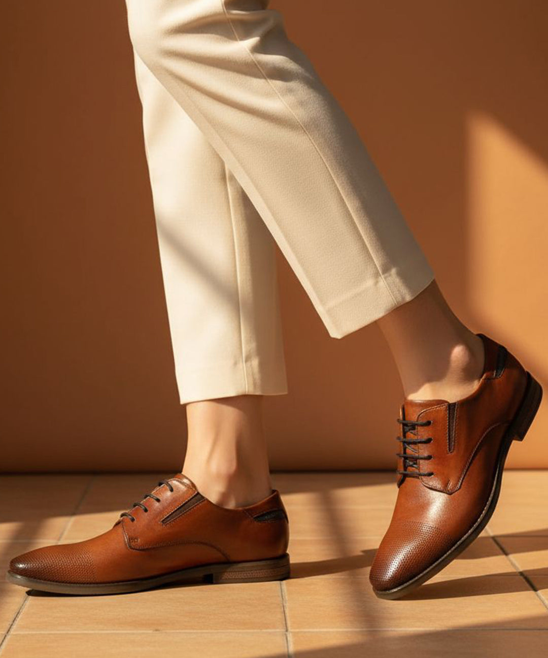 bugatti Menello cognac leather derby shoes with black laces, paired with beige pants.