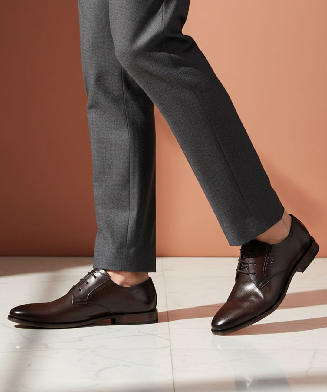 bugatti Gapo dark brown premium leather derby shoes with laces, paired with gray dress pants.
