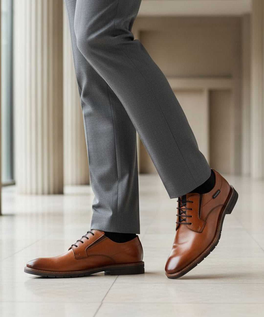 bugatti Mero cognac premium leather derby formal shoes with black laces, styled with gray dress pants and black socks.
