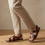 Lifestyle shot of bugatti Limon dark brown premium leather sandals with comfort back strap.
