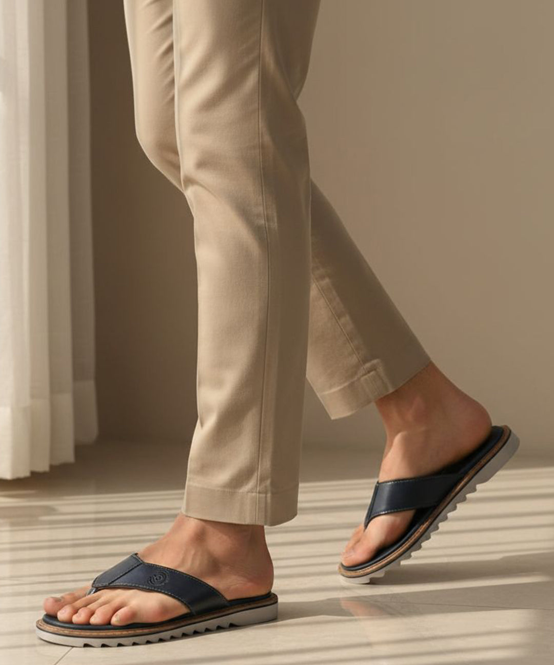 Lifestyle view of bugatti Limon sandals in dark blue premium leather, a comfortable thong style.
