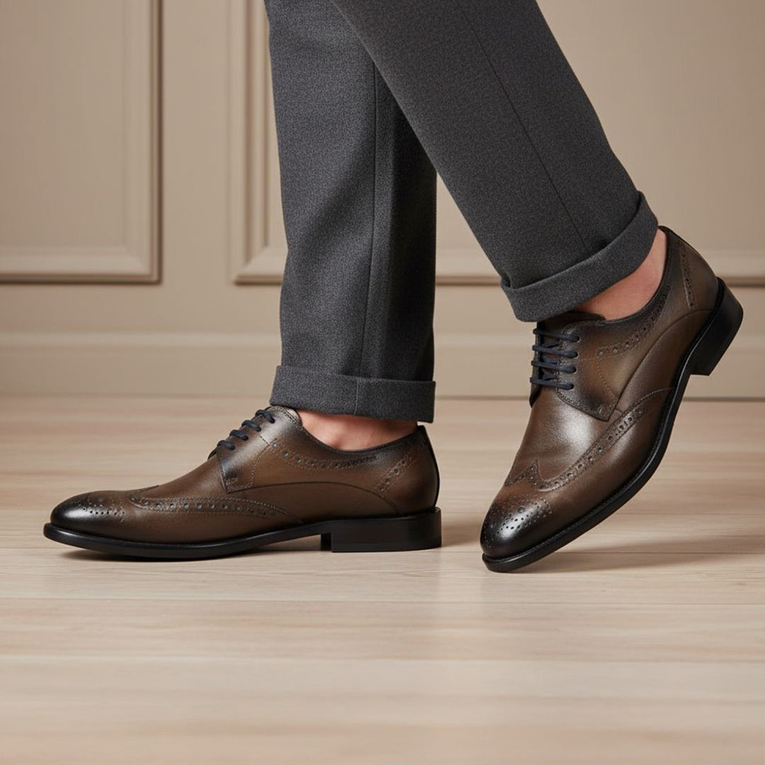 bugatti Livorno Flex Evo dark grey leather formal shoes, with brogue detailing, styled with grey trousers.
