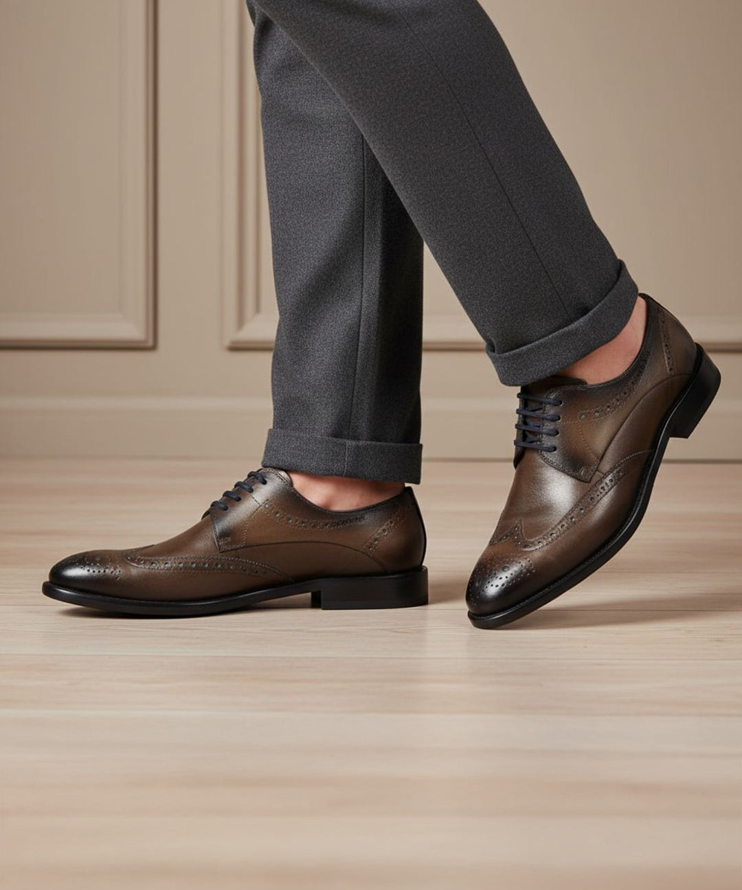 bugatti Livorno Flex Evo dark grey leather formal shoes, with brogue detailing, styled with grey trousers.
