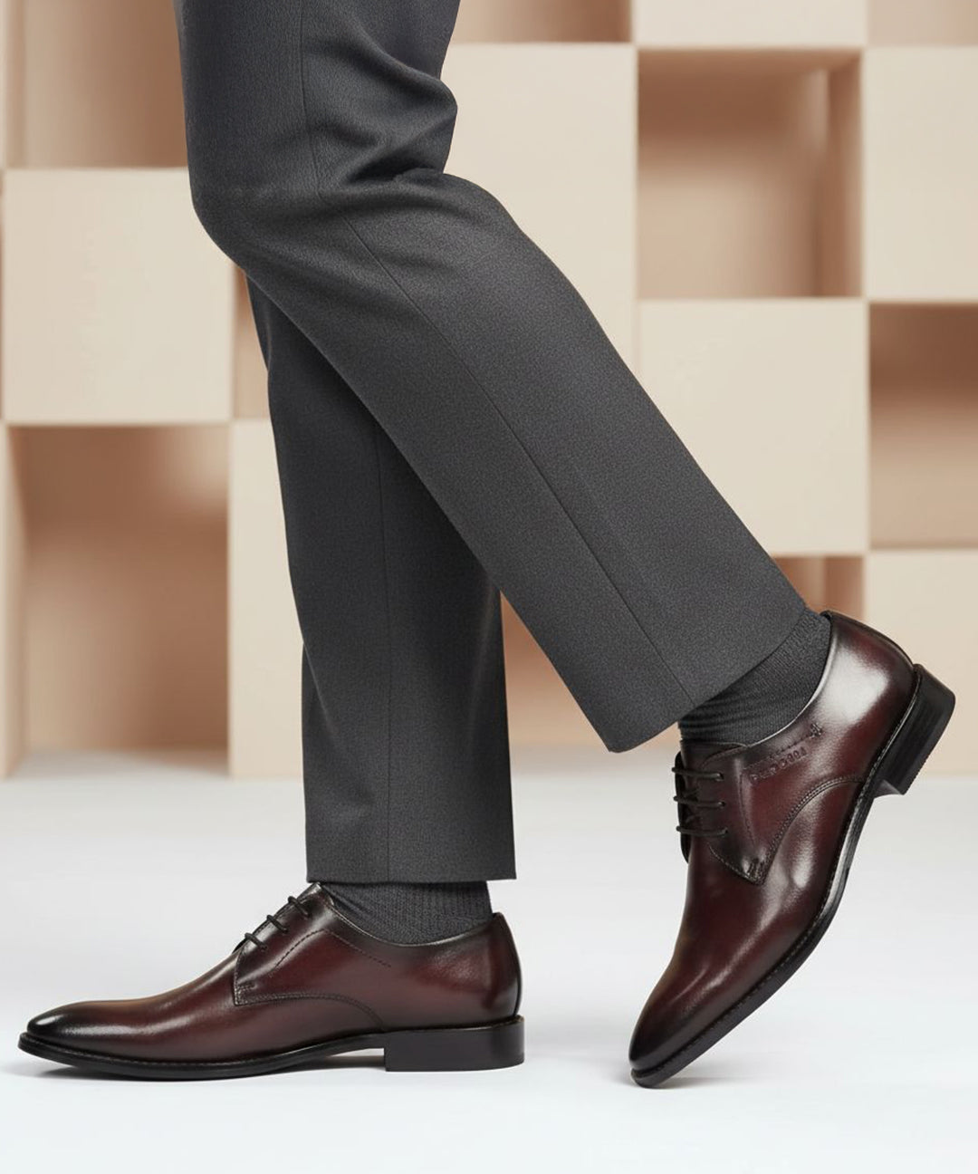 Lifestyle shot of bugatti Rico Flex bordo dress shoes, paired with grey dress pants and grey socks.