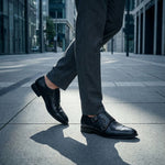 bugatti Zavinio black premium leather monk shoes with double buckle closure, gray pants, city background.