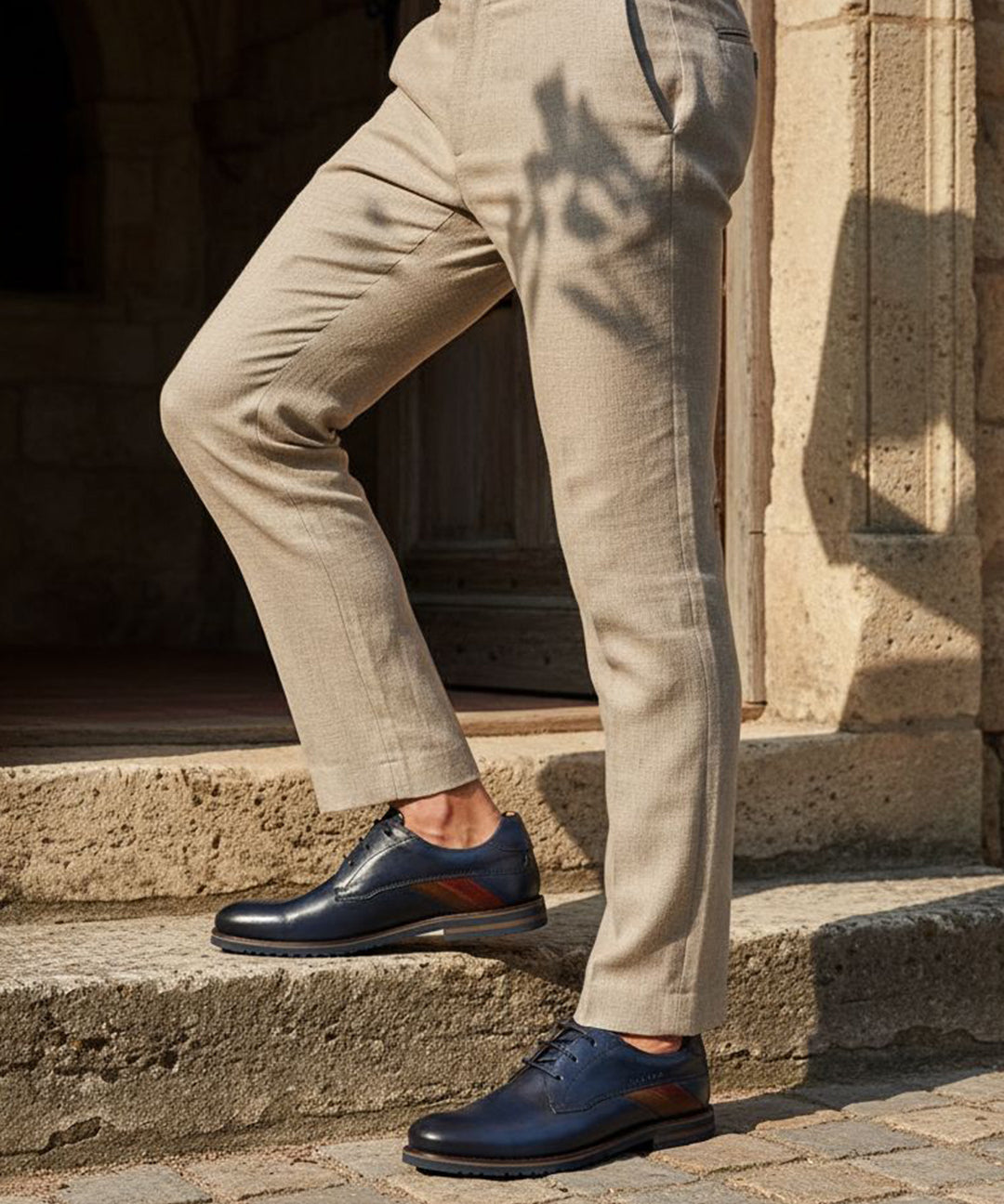 bugatti Caleo Exko dark blue leather derby shoes, accented with a brown stripe and paired with khaki trousers.
