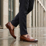 Lifestyle shot of bugatti Rico cognac premium leather slip-on formal shoes with a classic style.