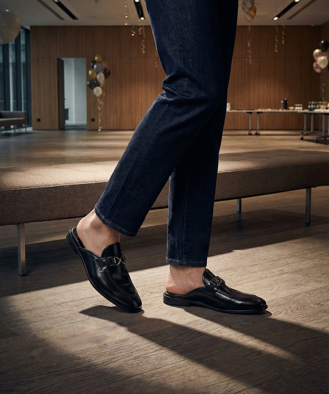 Lifestyle shot of bugatti Rico Black leather slip-on shoes, featuring a metal buckle detail.

