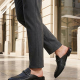 bugatti Rico black leather slip-on dress shoes with basket weave texture and a metal buckle.
