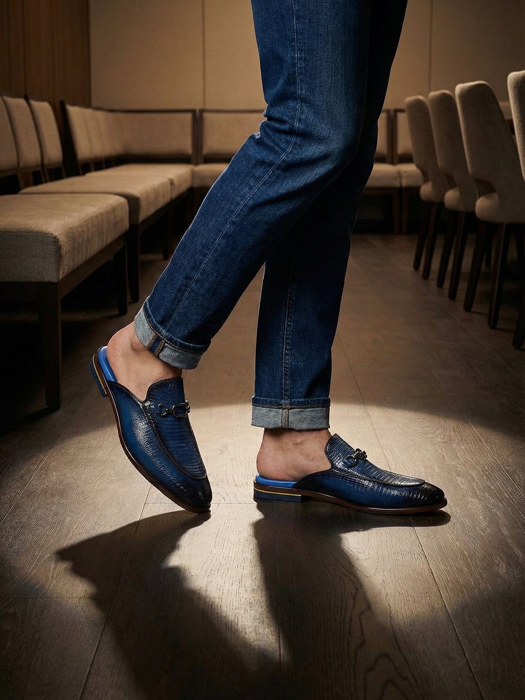 bugatti Rico Blue leather slip-on shoe with buckle detail, paired with blue denim jeans in a lifestyle shot.