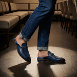bugatti Rico Blue leather slip-on shoe with buckle detail, paired with blue denim jeans in a lifestyle shot.