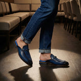 bugatti Rico Blue leather slip-on shoe with buckle detail, paired with blue denim jeans in a lifestyle shot.