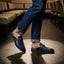 bugatti Rico Blue leather slip-on shoe with buckle detail, paired with blue denim jeans in a lifestyle shot.