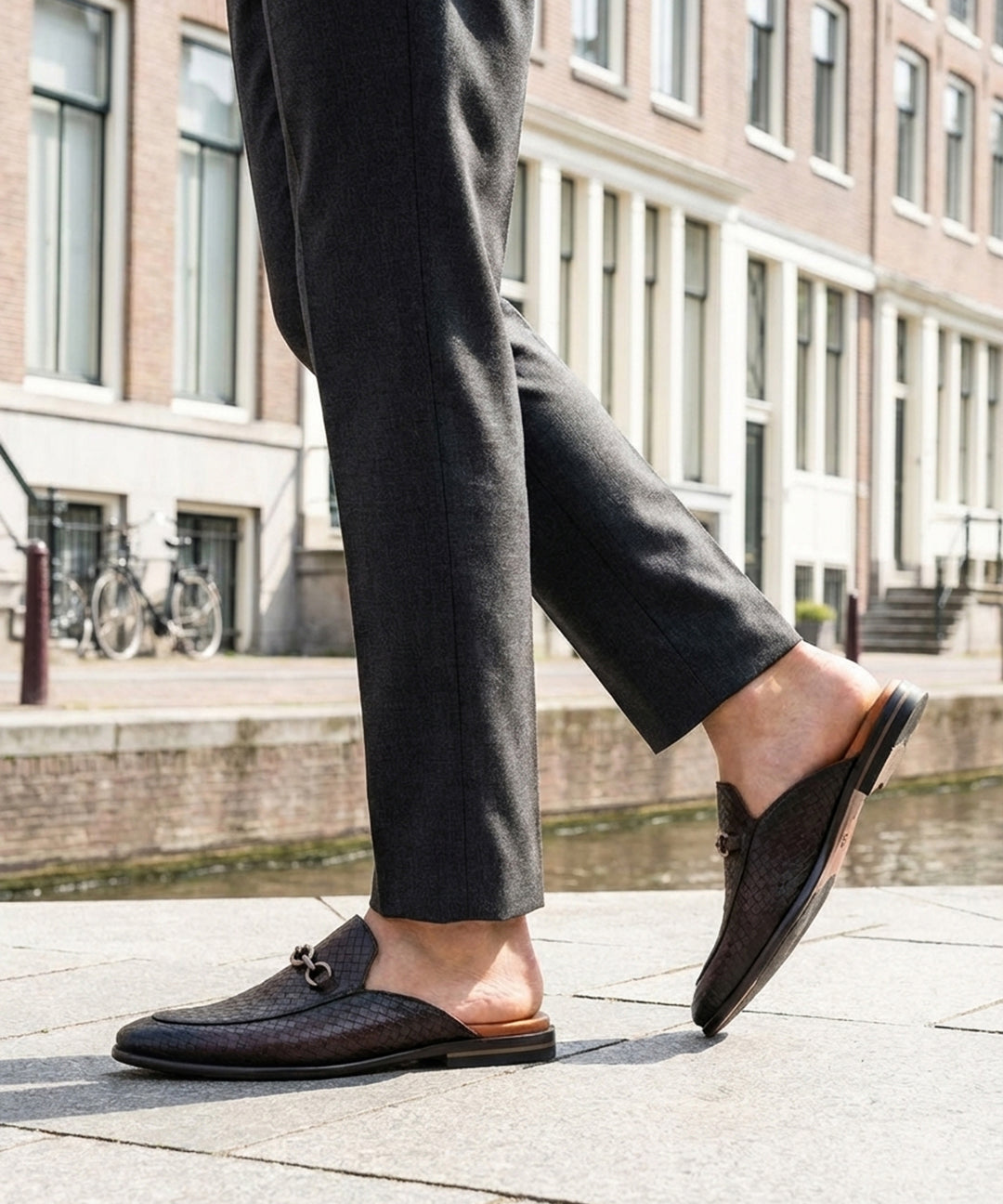 Lifestyle shot of bugatti Rico Brown premium leather slip-on shoe, featuring a woven texture and a metal horse-bit detail.
