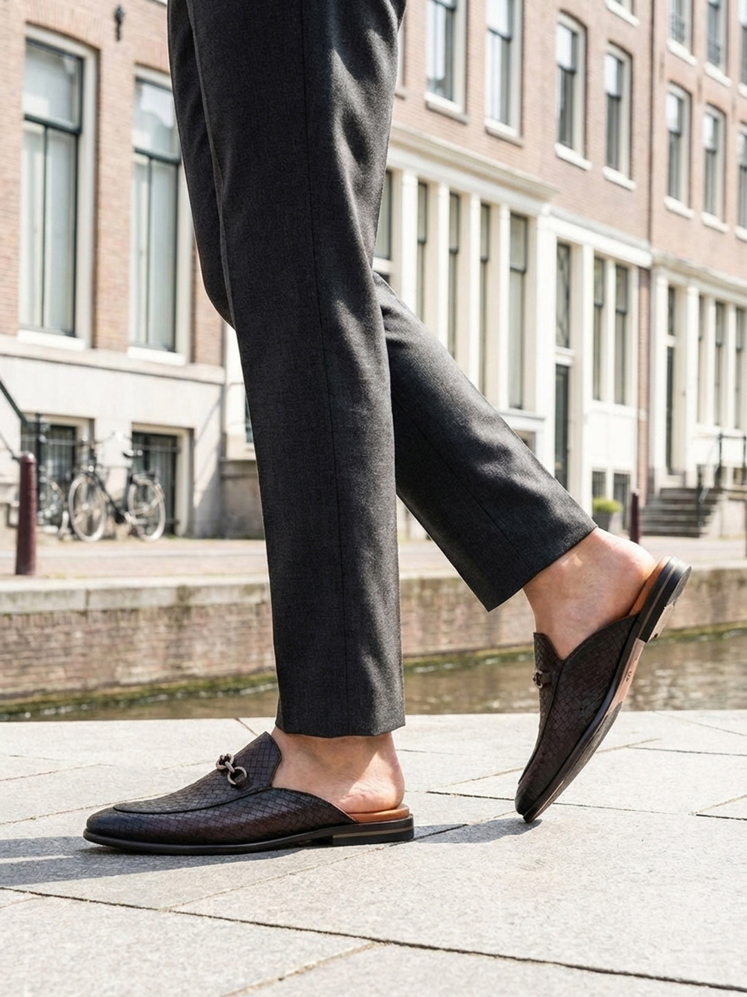 Lifestyle shot of bugatti Rico Brown premium leather slip-on shoe, featuring a woven texture and a metal horse-bit detail.
