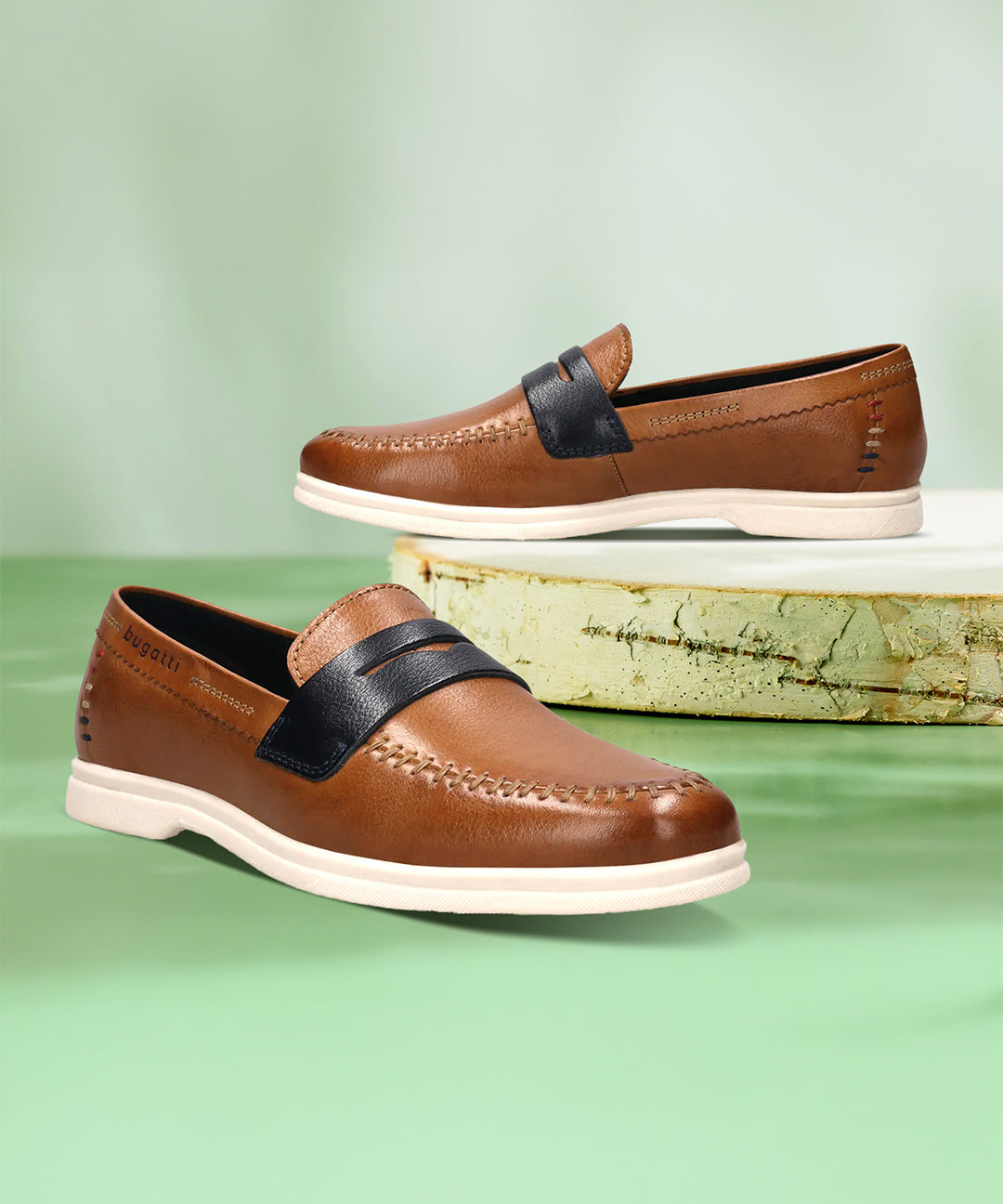 bugatti Sandiago slip-on shoes in cognac leather with a dark accent strap and white soles.