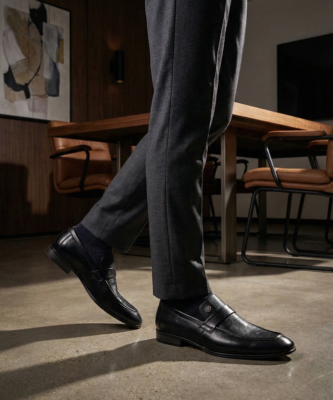 bugatti Matina black premium leather penny loafers with subtle texture, paired with dark gray dress pants and dress socks.
