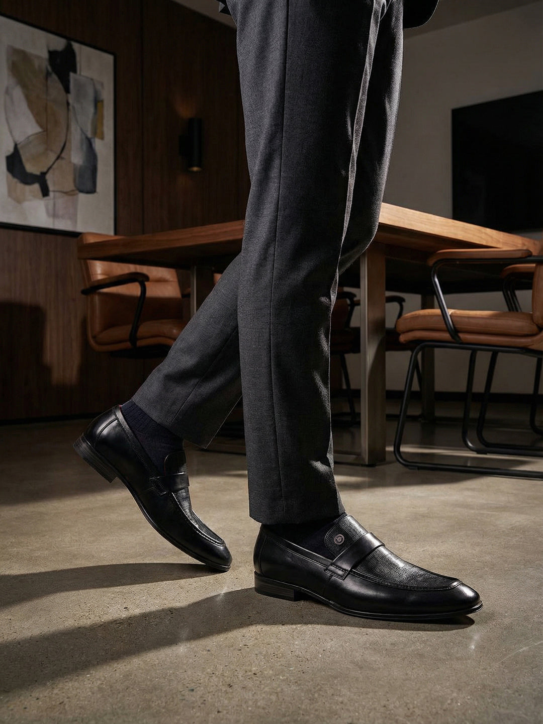 bugatti Matina black premium leather penny loafers with subtle texture, paired with dark gray dress pants and dress socks.