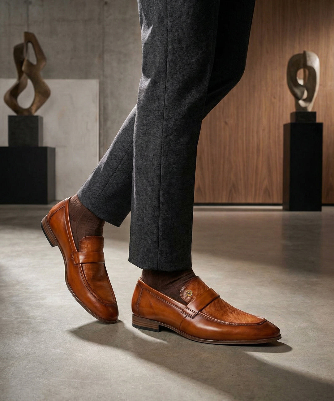 Lifestyle view of bugatti Matina yellow premium leather penny loafers with brown socks and grey slacks.
