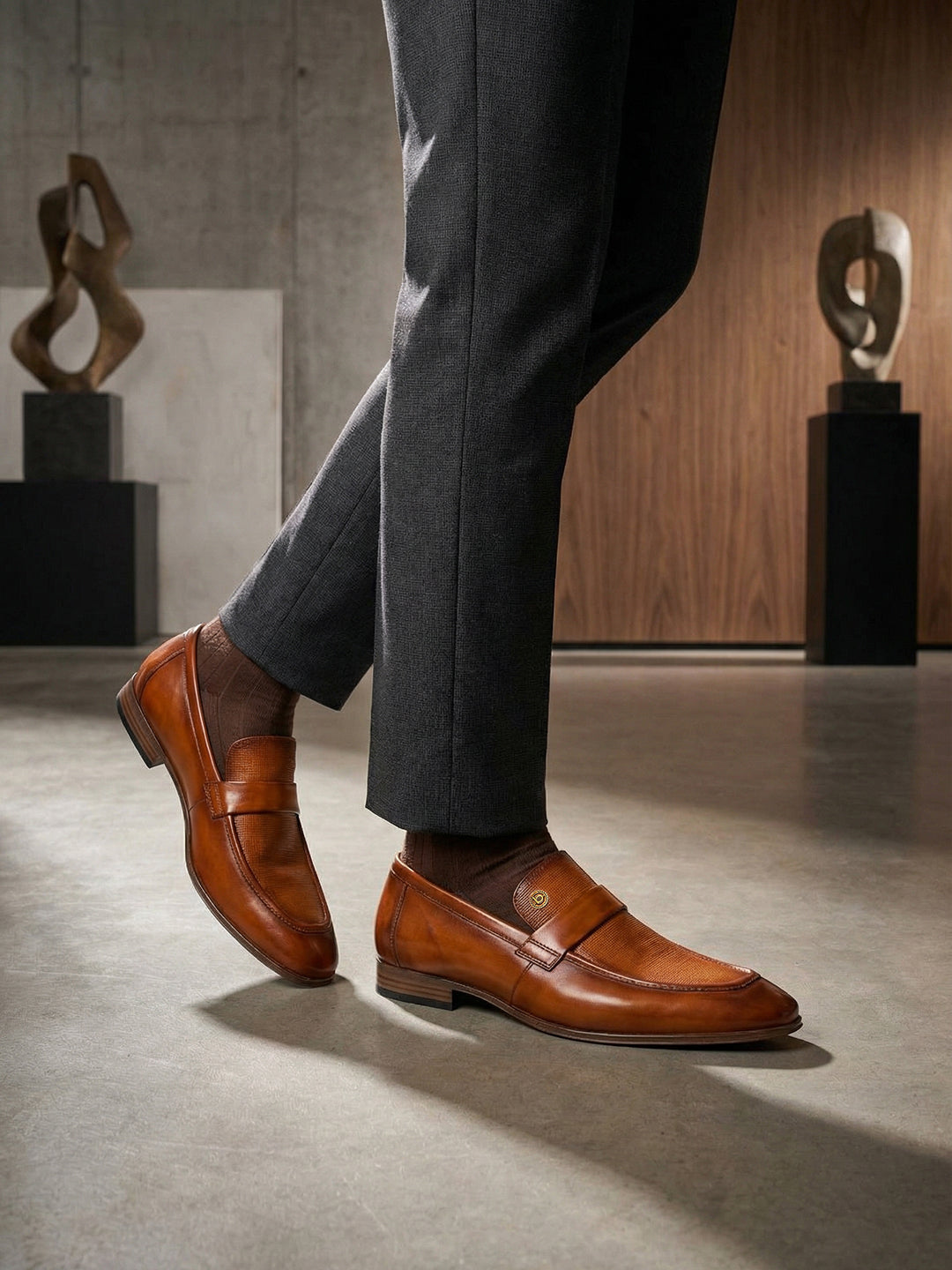 Lifestyle view of bugatti Matina yellow premium leather penny loafers with brown socks and grey slacks.
