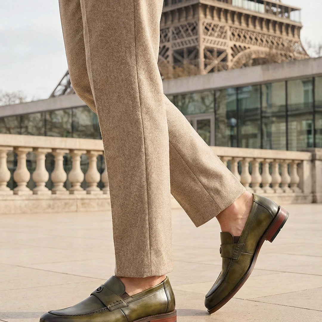 bugatti Sula Revo Green premium leather penny loafers, worn with tan trousers, with the Eiffel Tower in the background.