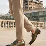 bugatti Sula Revo Green premium leather penny loafers, worn with tan trousers, with the Eiffel Tower in the background.