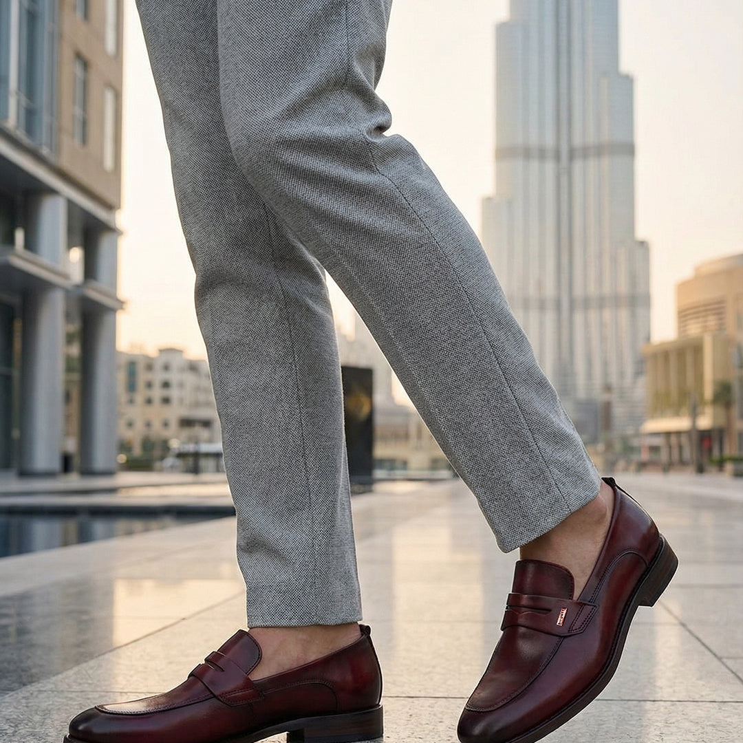 bugatti Sula Revo red leather loafers with a penny strap detail, styled with grey dress pants.
