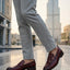 bugatti Sula Revo red leather loafers with a penny strap detail, styled with grey dress pants.
