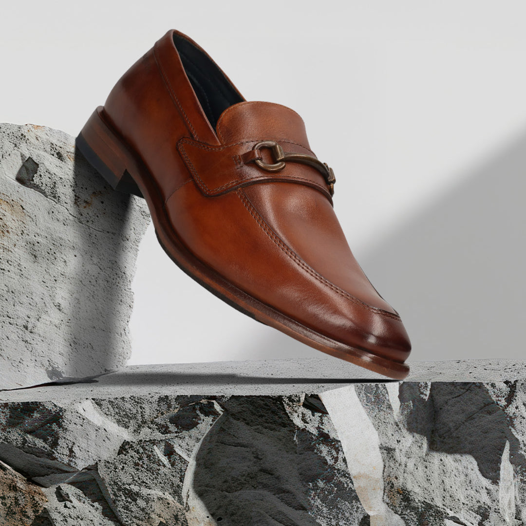 A cognac Men's bugatti Bit Loafer featuring a round toe apron toe, stacked heel. Made from premium genuine leather with a durable leather outsole, this slip-on design offers both style and comfort.