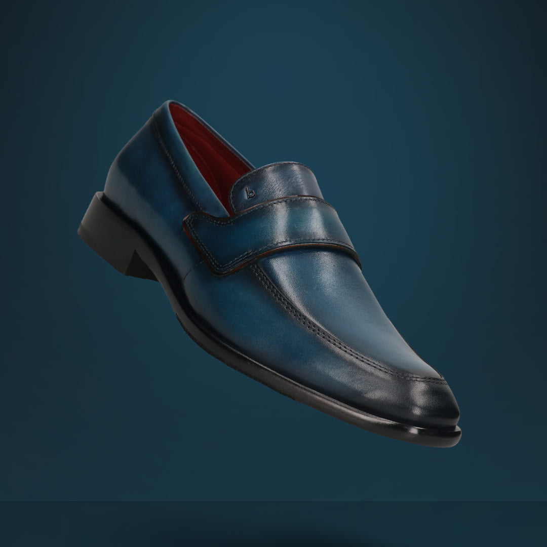 A blue Men's bugatti Penny Loafer featuring a round toe apron toe, stacked heel. Made from premium genuine leather with a durable leather outsole, this slip-on design offers both style and comfort.