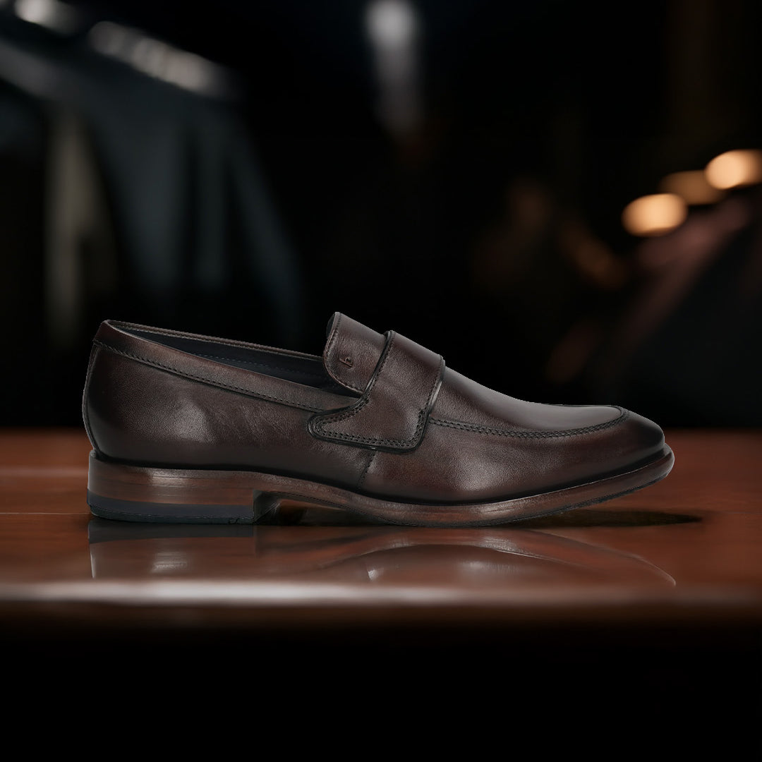 A brown Men's bugatti Penny Loafer featuring a round toe apron toe, stacked heel. Made from premium genuine leather with a durable leather outsole, this slip-on design offers both style and comfort.