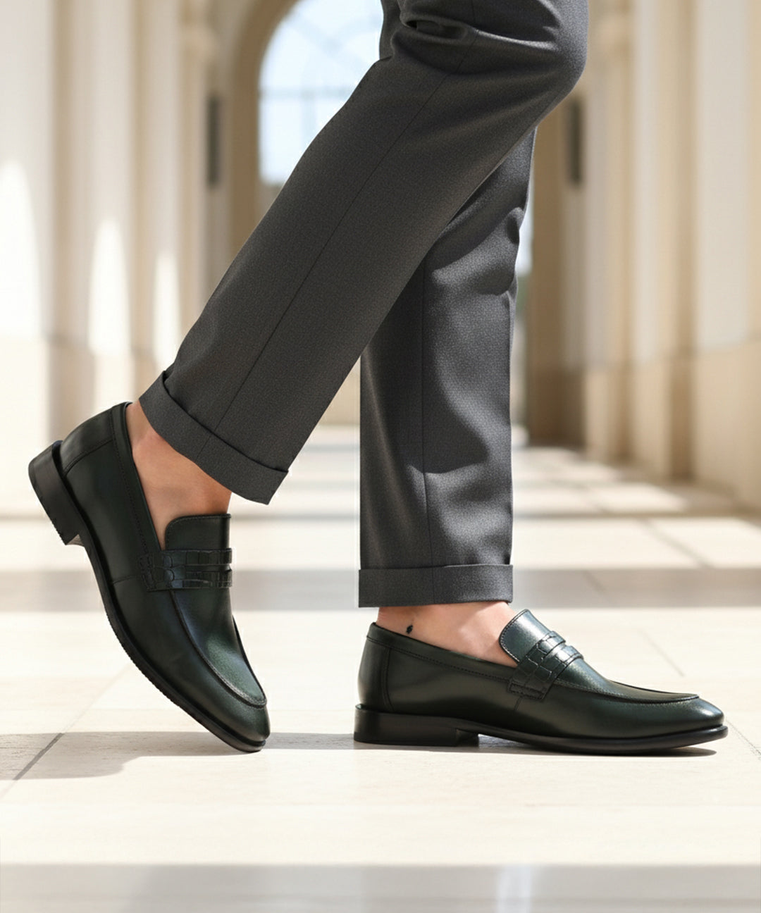 bugatti Mansueto Flex Revo penny loafers in dark green premium leather worn with grey dress pants.
